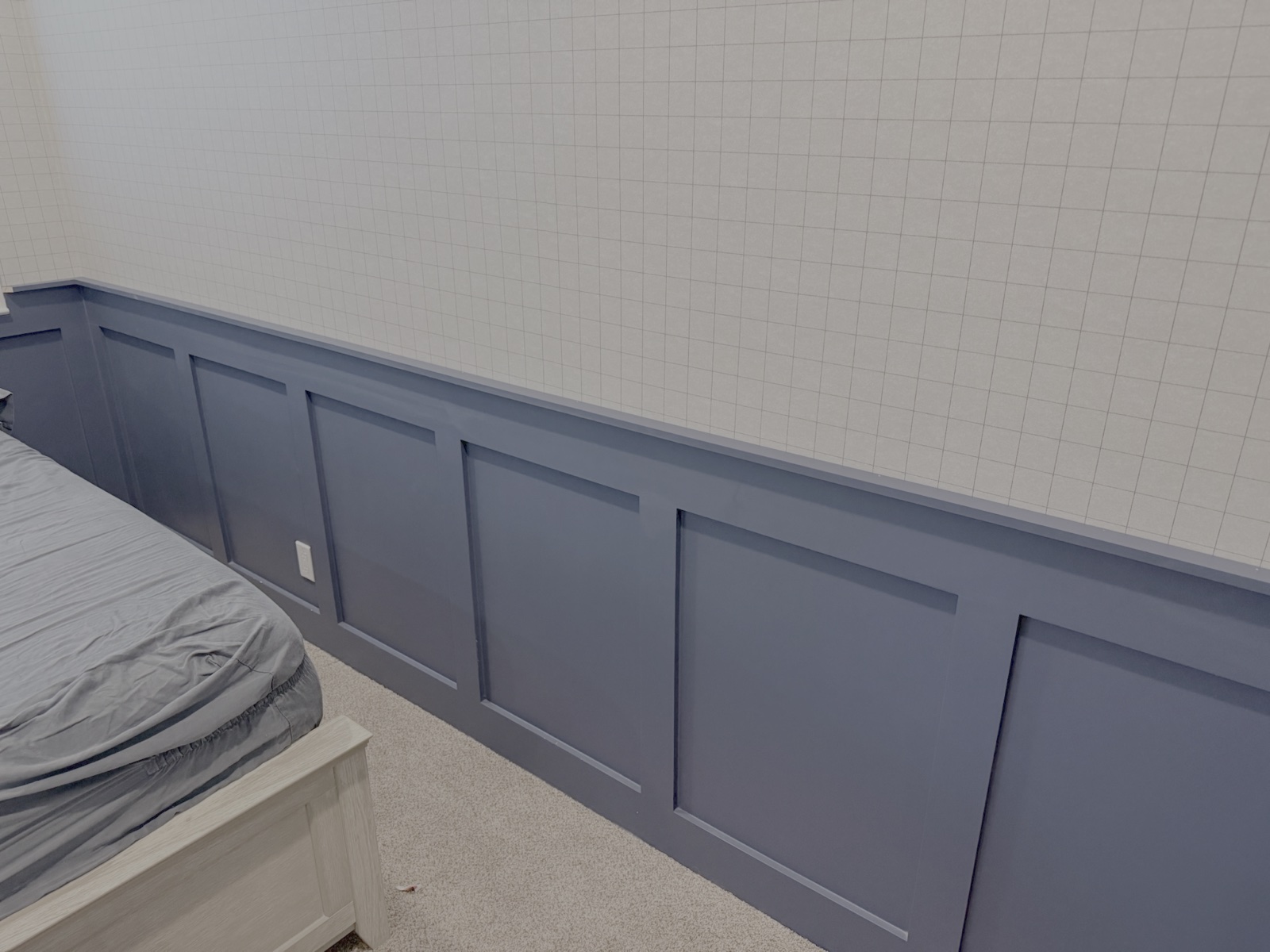 Custom slate blue board and batten wainscoting with decorative top cap moulding in master bedroom