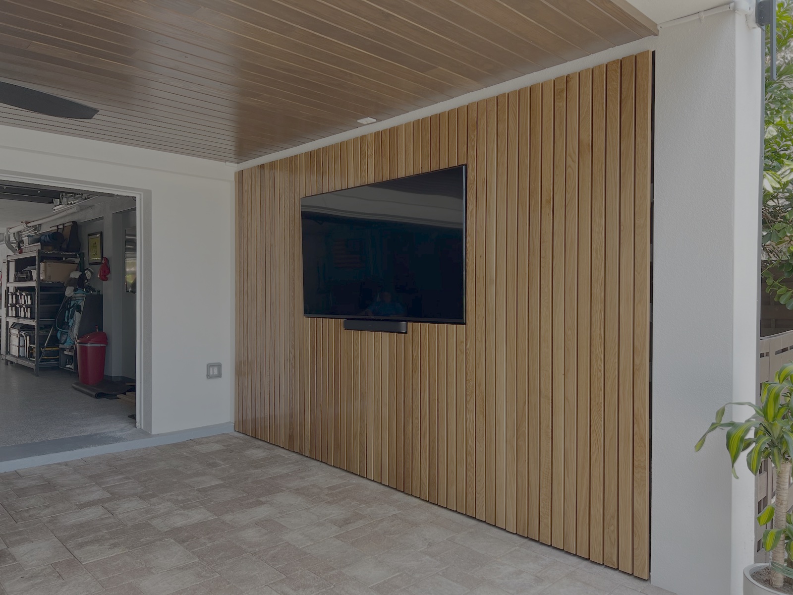 Covered outdoor patio lanai vertical wood slat TV wall and tongue-and-groove ceiling in Florida